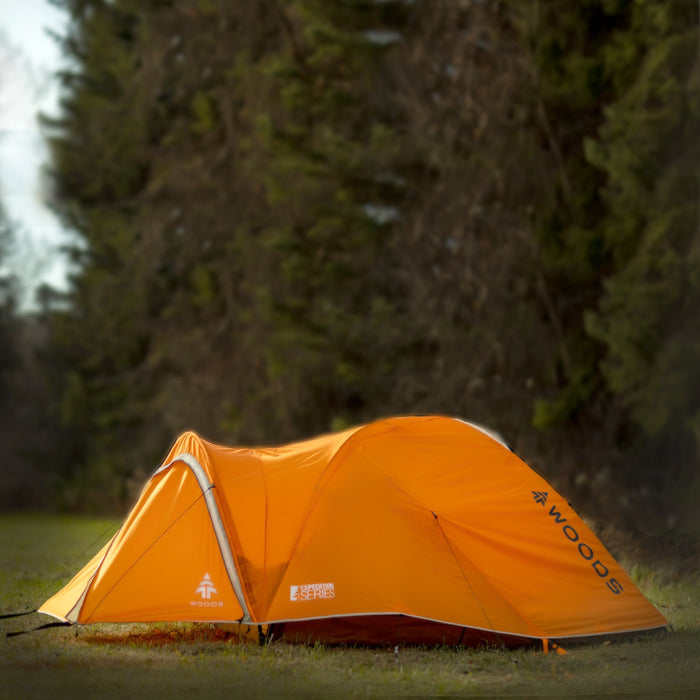 Side view of a fully built Woods Pinnacle Lightweight 2-Person 4-Season Tent on campground