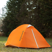 Load image into Gallery viewer, Back view of a Woods Pinnacle Lightweight 4-Person 4-Season Tent on grassy campground