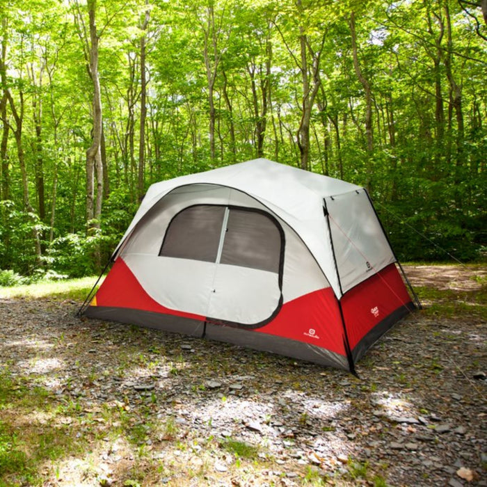 Fully built 8-person cabin tent with rainfly in red on campground