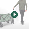 A person rolling the Woods Outdoor Collapsible Utility King Wagon in Sea Spray 