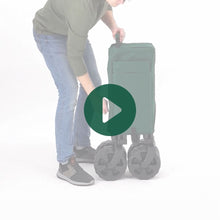 Load image into Gallery viewer, A man setting up the Woods outdoor collapsible utility king wagon in Green