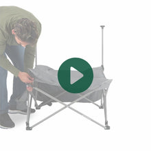 Load image into Gallery viewer, A man setting up the Woods Mammoth Chair in shade Gun Metal