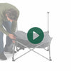 A man setting up the Woods Mammoth Chair in shade Gun Metal