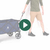 A person rolling the Woods Outdoor Collapsible Utility King Wagon in Navy