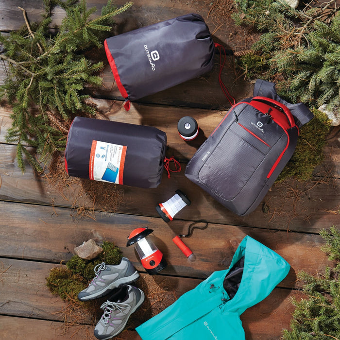 LED lantern and camp light set in red spread out next to other camping equipment