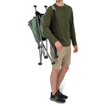 Load image into Gallery viewer, A person carrying the Woods Mammoth Folding Padded Camping Chair in Sea Spray partially rolled across their shoulder