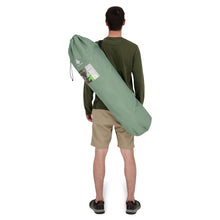 Load image into Gallery viewer, Behind view of a person carrying the Woods Mammoth Folding Padded Camping Chair in Sea Spray inside carry bag across their back