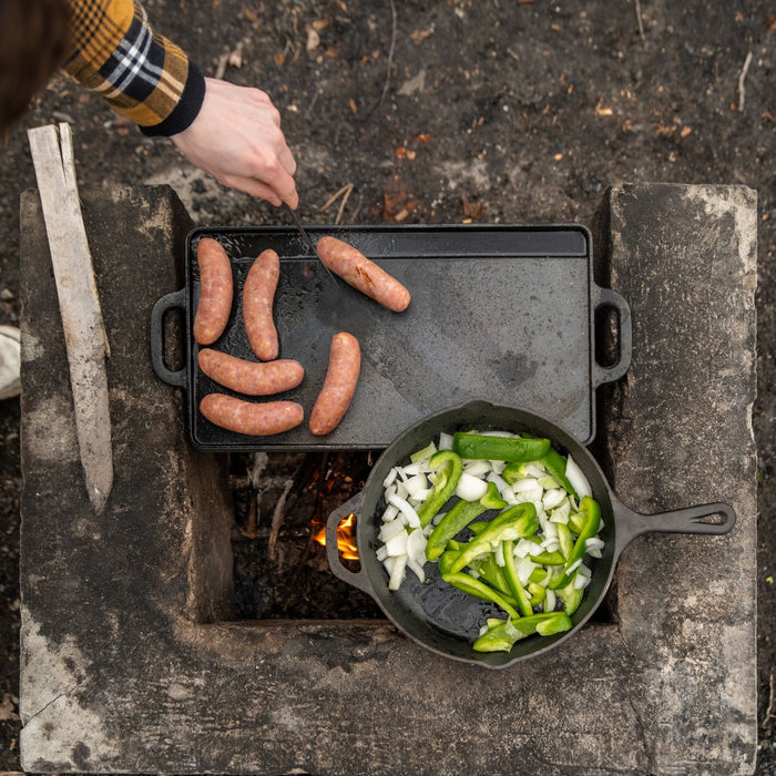 Birds eye view of sausages and vegetables cooking on top of the Woods Heritage Skillet and griddle 