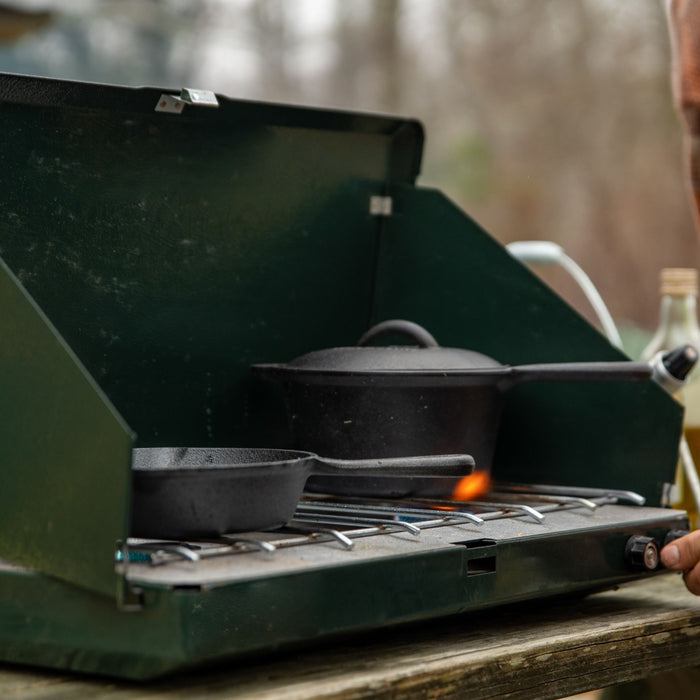 Woods Heritage Cast Iron Pot and Skillet next to each other on portable stove