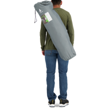 Load image into Gallery viewer, Behind view of a person carrying the Woods Mammoth Folding Padded Camping Chair in color Gun Metal inside a carry bag across their back