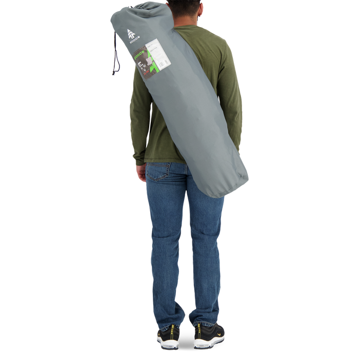 Behind view of a person carrying the Woods Mammoth Folding Padded Camping Chair in color Gun Metal inside a carry bag across their back