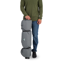 Load image into Gallery viewer, A person standing next to a rolled up Woods Mammoth Folding Padded Camping Chair in color Gun Metal