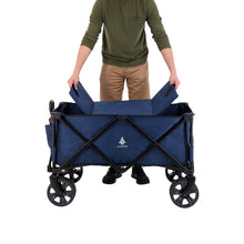 Load image into Gallery viewer, A person putting in the base on the Woods Outdoor Collapsible Utility King Wagon in Navy