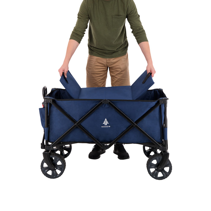 A person putting in the base on the Woods Outdoor Collapsible Utility King Wagon in Navy