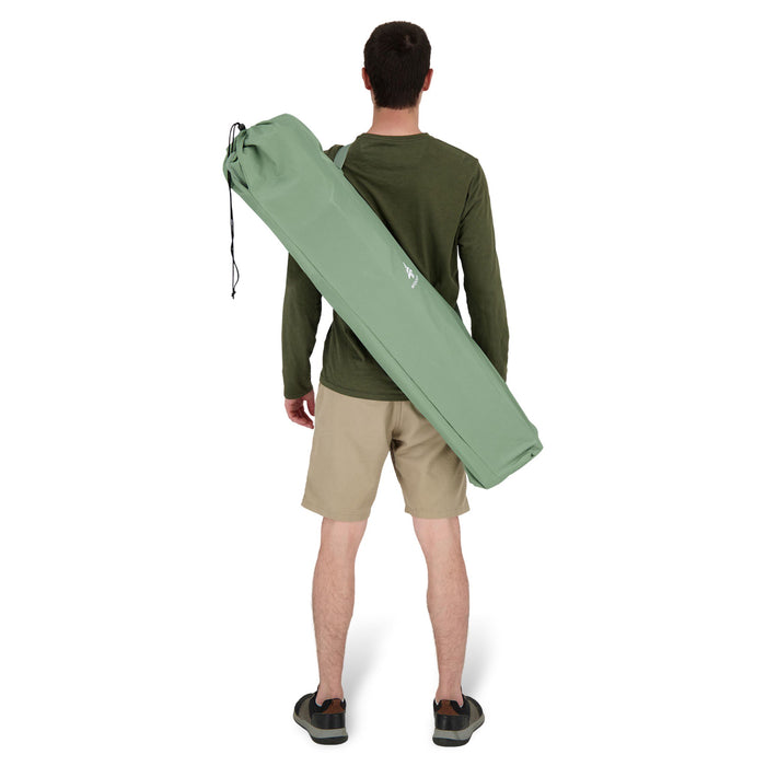 Behind view of a person carrying the Woods Siesta Folding Reclining Padded Camping Chair in Sea Spray inside carry bag across their back