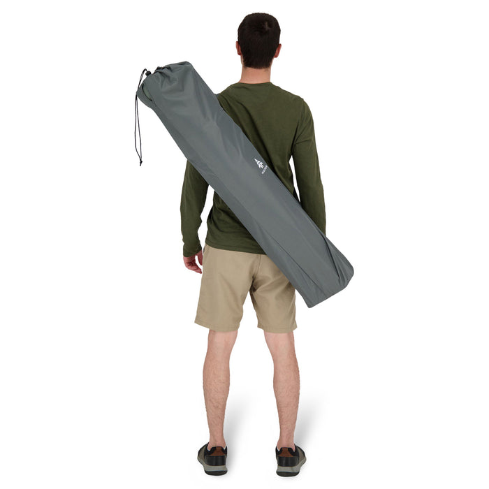 Behind view of a person carrying the Woods Siesta Folding Reclining Padded Camping Chair in color Gun Metal inside carry bag across their back