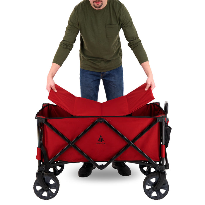 A person putting in the base on the Woods Outdoor Collapsible Utility King Wagon in Red
