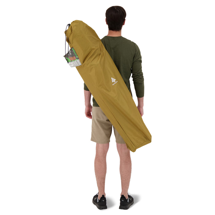 Behind view of a person carrying the Woods Kaslo Folding Camping Rocker Chair in Dijon across their back