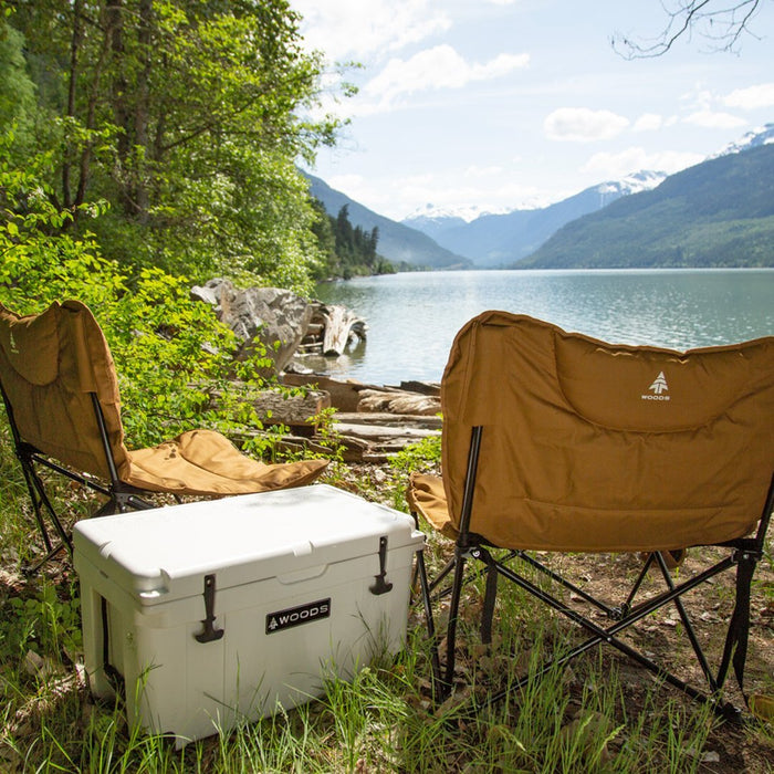 Two Woods Mammoth Folding Padded Camping Chairs in Dijon next to a white cooler overlooking the water