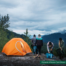Load image into Gallery viewer, Four people standing by a fully built Woods Pinnacle Lightweight 2-Person 4-Season Tent on campground