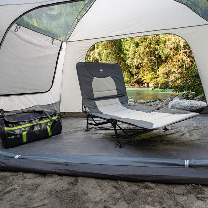 Woods Portable Quick Set-Up Adjustable 2-in-1 Camping Lounger in Gray next to a duffel bag inside a tent on campground