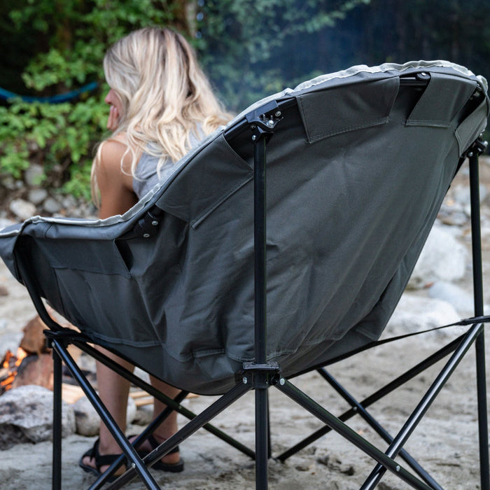 A person sitting on the Woods Strathcona Fully Padded Folding Camping Bucket Chair in Gray from the back